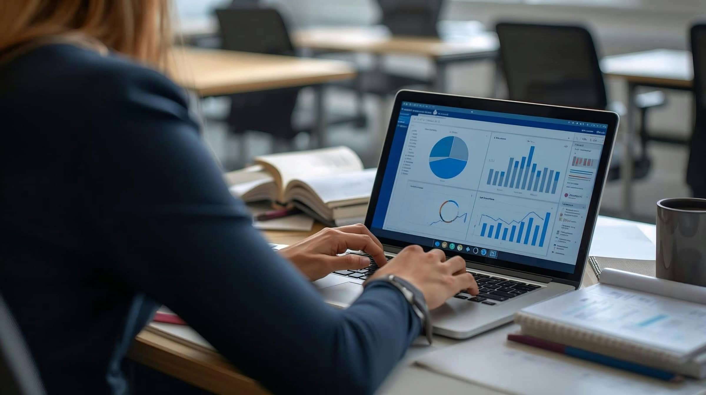 Employee reviewing charts and reports on a laptop